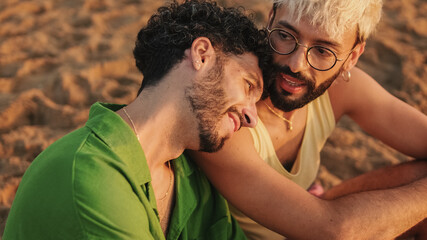 Romantic moments, homosexual couple enjoying intercourse with each other while sitting on the beach...
