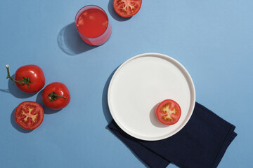 Tomato juice glass decorated with tomatoes and a dish placed on a fabric. Tomatoes protect the skin from the harmful effects of the environment