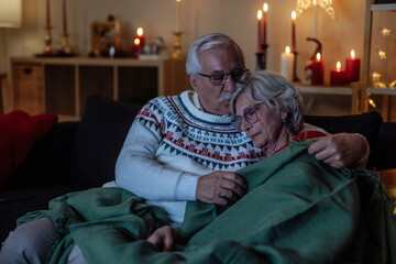 Older couple watching a tv and feeling sleepy during Christmas holidays