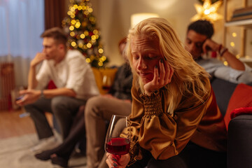 Albino girl sitting, holding wine and looking sad during Christmas holidays