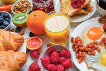 Breakfast buffet continental and full english. Large selection of breakfast food on the table with egg, toast, orange juice, croissant, coffee, fruits and nuts