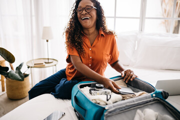 Senior woman packing travel essentials for her dream trip
