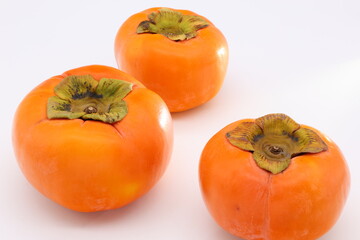 白背景の上に乗ったオレンジ色の柿