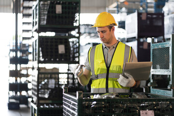 Storage warehouse and manufacturing concept. Male warehouse worker working with laptop computer and...