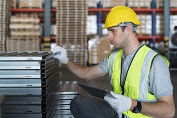Storage warehouse and manufacturing concept. Male warehouse worker working with tablet and...