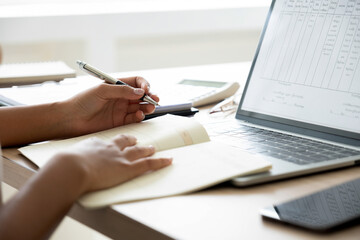 Fototapeta premium Busineswoman or employee working on laptop and papers.