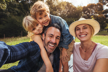 Cheerful family making selfie on picnic - obrazy, fototapety, plakaty