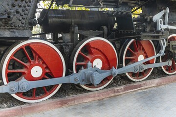 Fototapeta na wymiar Mechanical wheels of a transport steam locomotive on rails