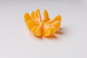 Tangerine in a split peel on a white table.