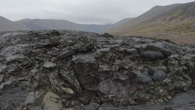 DOLLY SHOT - View of cracked lava crust or ingenious rock and steam cooled down from the 2021 eruption of Fagradalsfjall volcano in Geldingadalir Valley on Reykjanes Peninsula in Iceland.
