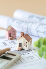 ミニチュアの家と設計図を使ったマイホームの購入を考えるイメージ