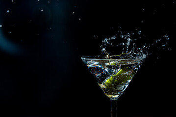 splash in a glass with lime slice on a black background