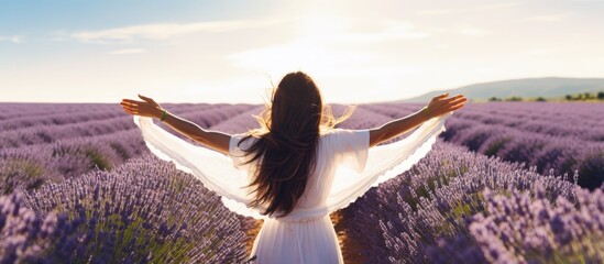 Lavender field in France a free woman enjoying nature with open arms in a white dress copy space image