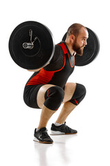 Strong, muscular, bearded man, bodybuilder doing squats and lifting barbell, heavy weights against...