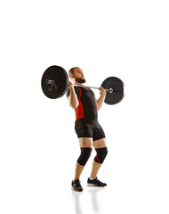 Athletic, muscular, strong man training, lifting heavy barbell, weights against white background