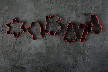 A row of red candy cutters on a concrete background. Christmas background. Advent time.  Natural modern Christmas background, banner. 
