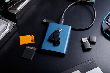 Close-up view of  SSD portable, USB thumb drive, SD card on black background.
