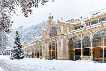 Snow-covered main colonnade with Christmas tree in spa town Marianske Lazne (Marienbad) - Czech...