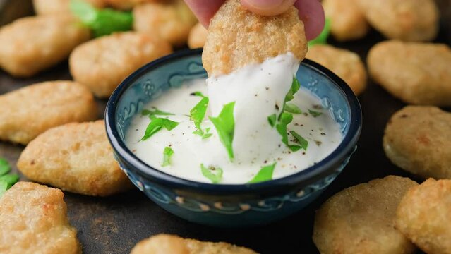 Dipping Jalapeno Popper cheese in sauce. party food bites