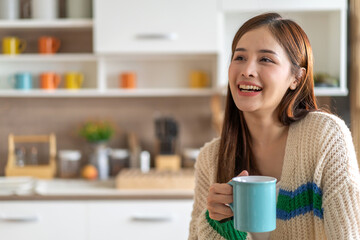 Portrait of smiling happy cheerful beauty pretty asian woman relaxing drinking and looking at cup of hot coffee or tea.Girl felling enjoy having breakfast in holiday morning vacation on bed at home.