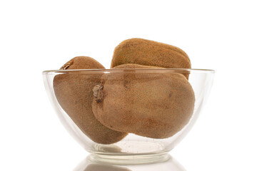 Three ripe sweet kiwis in a glass dish, macro, isolated on white background.