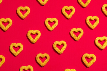 Fototapeta premium Small heart-shaped cookies on a red background.
