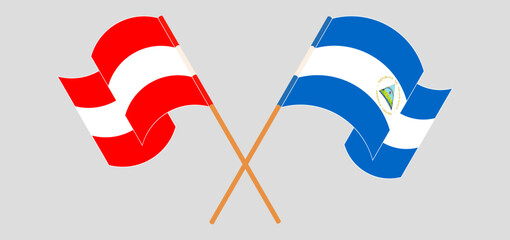 Crossed and waving flags of Austria and Nicaragua