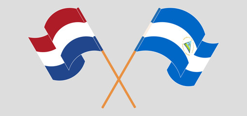 Crossed and waving flags of the Netherlands and Nicaragua