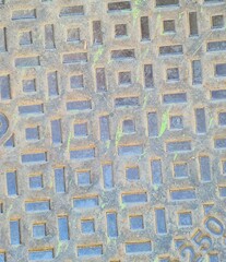 evocative texture image of a manhole with regular shapes