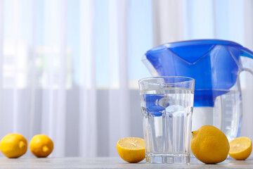 Water filter with fresh lemons and glass