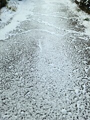 Snow on asphalt on a small german road..