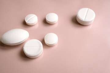  A handful of pills on pink background