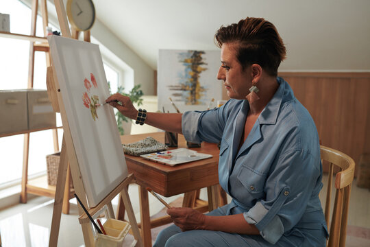 Creative woman enjoying painting flowers with acrylic