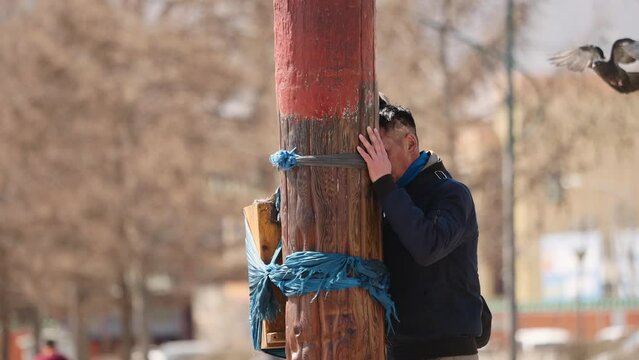 Man praying near Gandan(Gandantegchinlen) Monastery in Ulabaatar, Mongolia. 05-01-2022. 