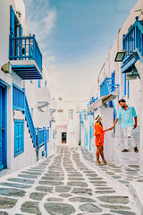 Mykonos Greece, couple of men and woman on vacation at the Greek Island Mykonos, a girl in dress on the whitewashed streets of Little Venice Mykonos Greece Europe