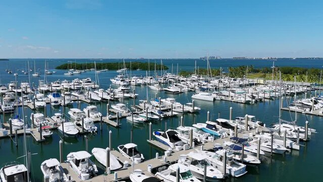 Stunning aerial view of luxury yachts and motorboats docked in spectecular Crandon Marina in Florida. Rich luxury water transport near palm groves in Key Biscayne village