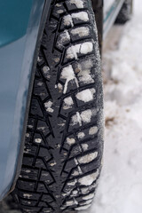 Car tire in winter on the road covered with snow.
