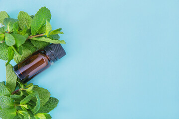 Dark glass essential oil bottle with bunch of peppermint