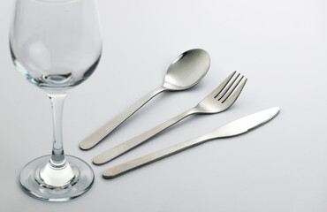 Wine glass and cutlery isolated on white. Table setting. Spoon fork and knife