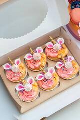 Box with beautiful gradient pink Unicorn theme cupcakes with little cute fondant ears and golden horn. Gift for a little boy or girl