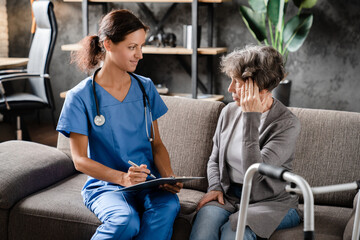 Nurse medical worker caregiver listening to complaints, symptoms of old senior disabled handicapped...