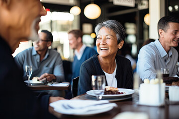 A cheerful group of friends, including seniors and adults, enjoy a happy meal together in a restaurant, sharing laughter and togetherness.