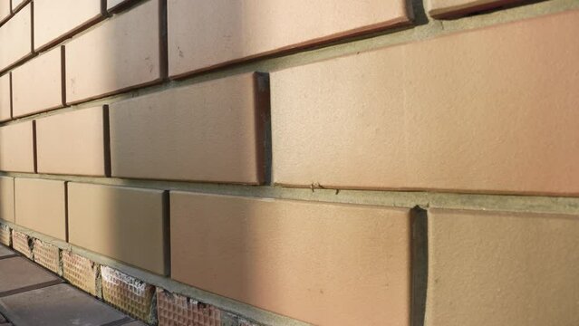 Decorative brick on the facade of a building, close-up. Brick wall texture background. Modern brick fa ade of an office building. The architectural facade of the building is made of red brick.