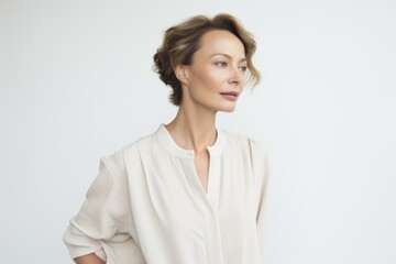 Fototapeta premium Caucasian woman posing gracefully against a white background. Elegantl style, wearing a classic outfit with subtle accessories. Generative AI.