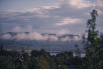 Obraz premium Low rain clouds in misty forest. The lifting of the fog at dawn. The water cycle in nature