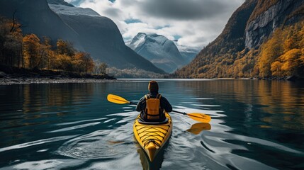 person is paddling a yellow kayak along the edge of a fjord in norway