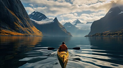 person is paddling a yellow kayak along the edge of a fjord in norway