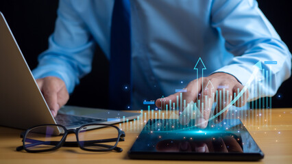 Businessman taps his finger on his tablet to display a graph with arrow for the future growth plan of his organization. finance, management, plan, management, strategy,