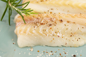 filet de colin cru, en gros plan, dans une assiette	