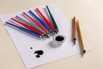 Portes plume de calligraphie en bois et plastique avec son pot d'encre, du papier et une tâche d'encre